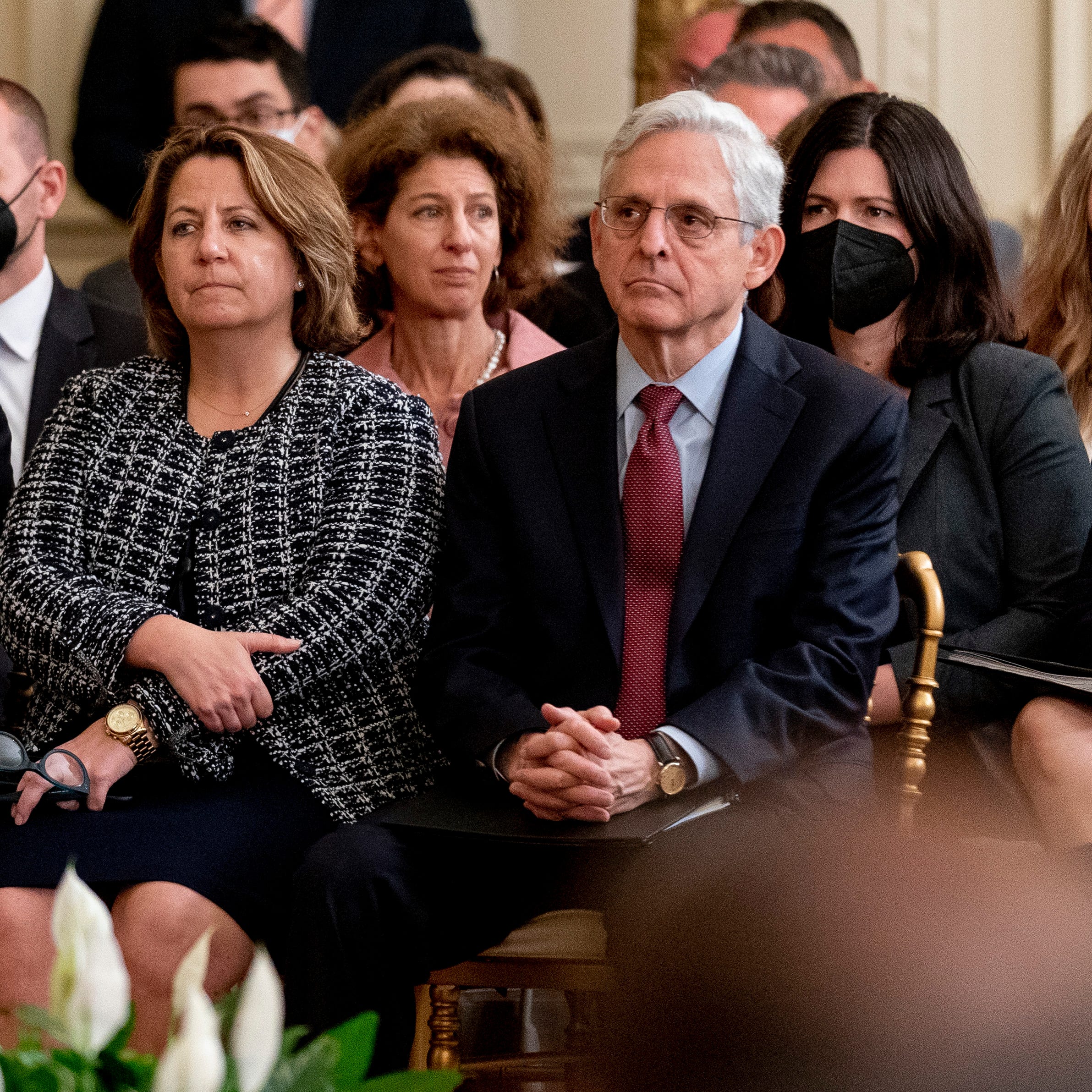 Attorney General Merrick Garland, right, accompanied by Deputy Attorney General Lisa Monaco, center left, listen as President Joe Biden speaks during a Public Safety Officer Medal of Valor event in the East Room of the White House, Monday, May 16, 2022, in Washington. (AP Photo/Andrew Harnik) ORG XMIT: DCAH113