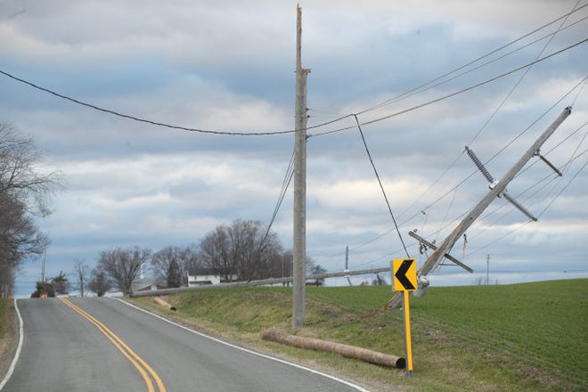 High winds toppled utility poles, which took down power lines on Wooster Street near Alabama Avenue in Tuscarawas Township on . Saturday.