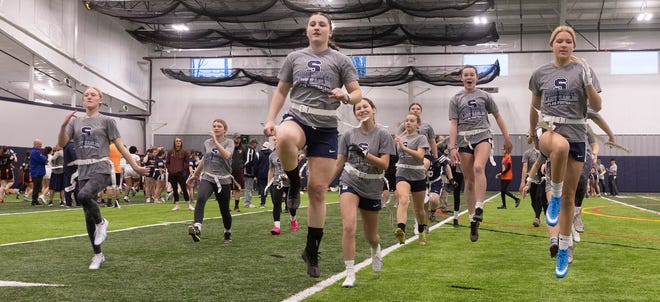 Middletown South's girls flag football team warm up before a clinic given by Giants' quarter Daniel Jones and former Giants' quarterback Eli Manning on March 25 at Manasquan.