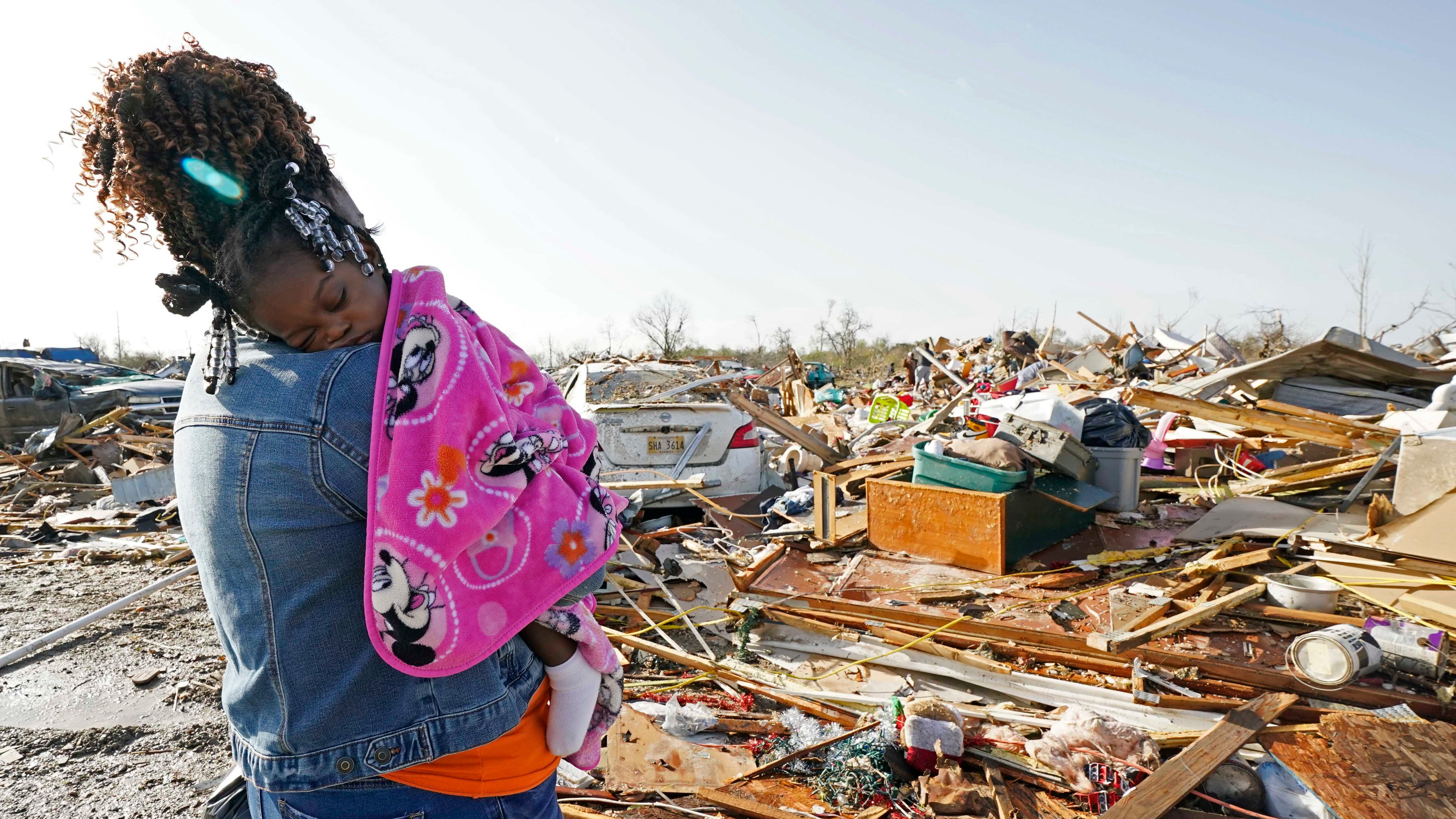Wonder Bolden cradles her year-old grand daughter Journey Bolden as she surveys the remains of her mother's tornado-demolished mobile home in Rolling Fork, Miss., Saturday, March 25, 2023.    Emergency officials in Mississippi say several people have been killed by tornadoes that tore through the state on Friday night, destroying buildings and knocking out power as severe weather produced hail the size of golf balls moved through several southern states.