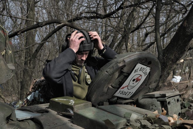 A Ukrainian serviceman gets into a T-72 tank on the front lines near Bakhmut on March 26, 2023.