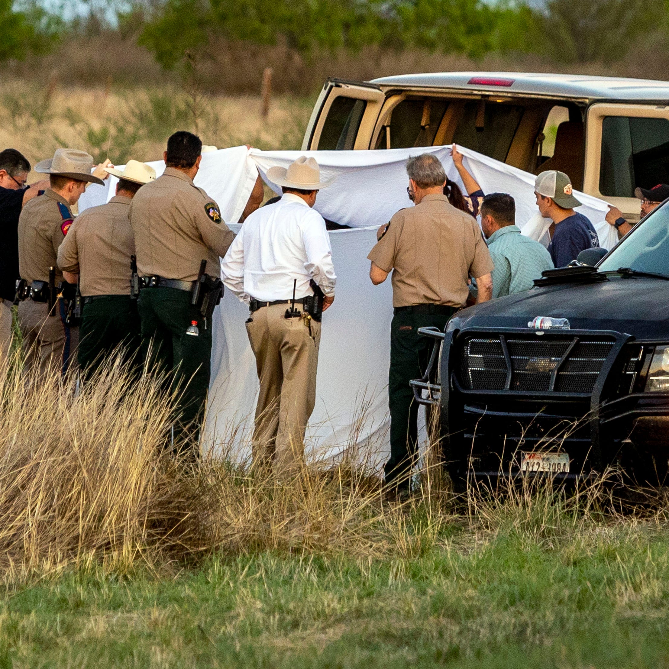 Officials investigate the scene where migrants were found trapped in a train car, Friday, March 24, 2023, in Uvalde, Texas. Union Pacific railroad said in a statement that the people were found in two cars on the train traveling east from Eagle Pass bound for San Antonio.