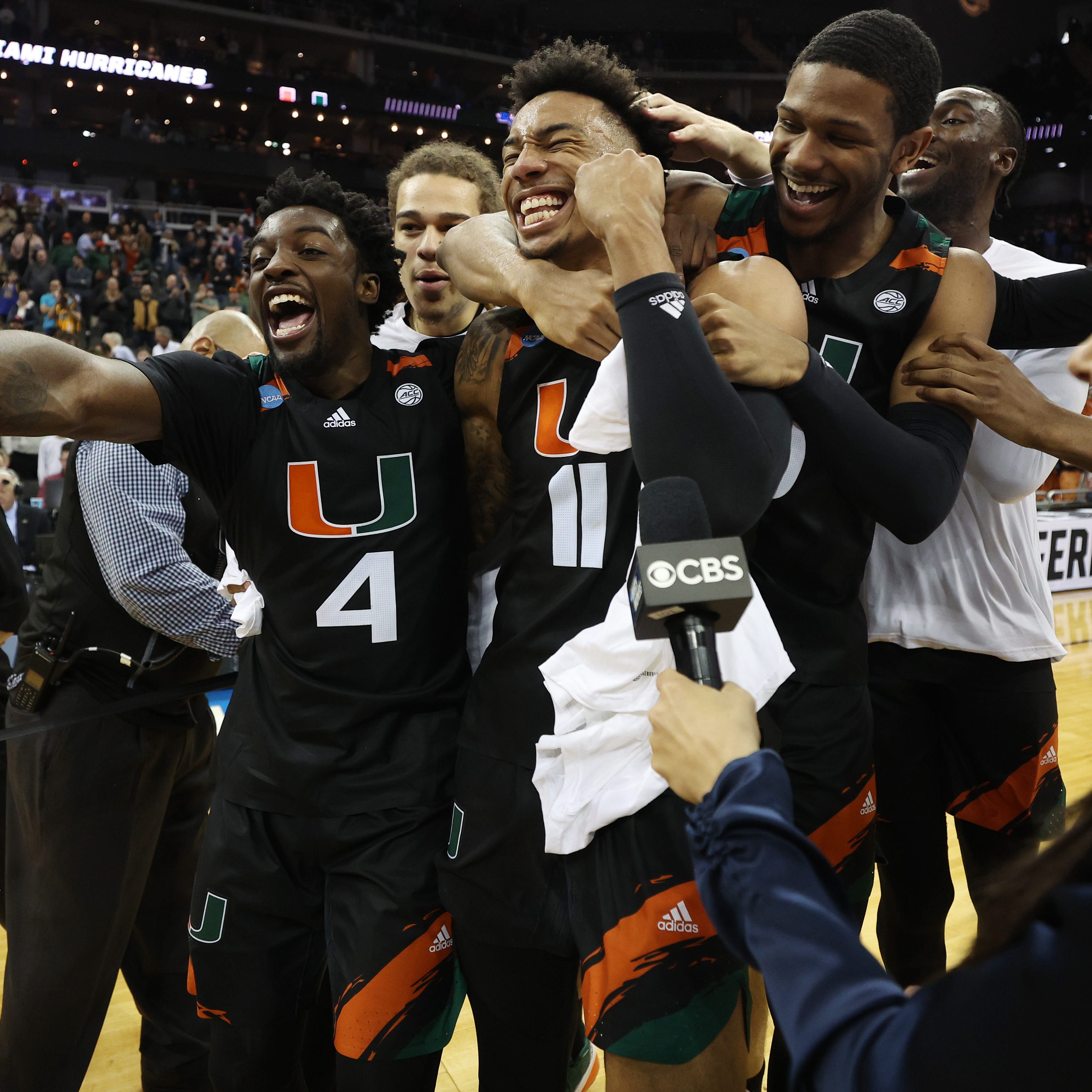 Miami (Fla.) players Bensley Joseph (4) and Jordan Miller (11) celebrate with teammates after defeating Texas in the Midwest Regional championship game of the NCAA men's tournament at T-Mobile Center.