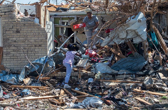Alaina Dean, 8, and her mother, Shannekia Miles, salvage what they can from their home in Rolling Fork, Miss., on March 25, 2023, after a tornado cut through the small Delta town.
