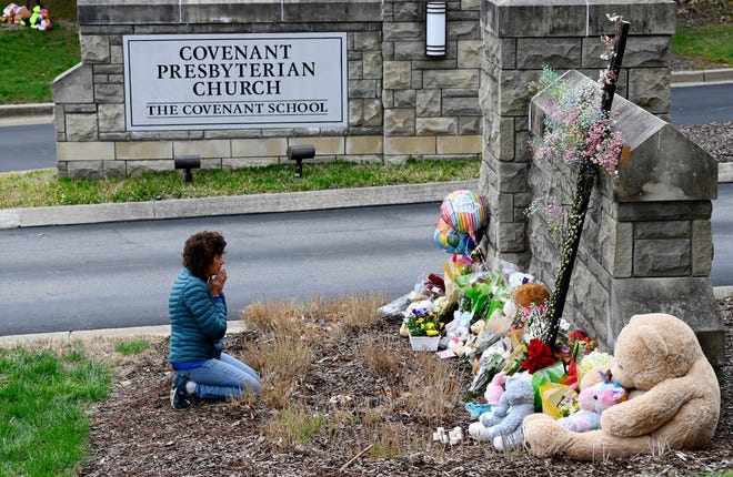 Robin Wolfeden prays in front of a makeshift memorial at the entrance to the Covenant School Tuesday, March 28, 2023, in Nashville, Tenn. Three children and three school staff members were killed by a former student in Monday’s mass shooting.