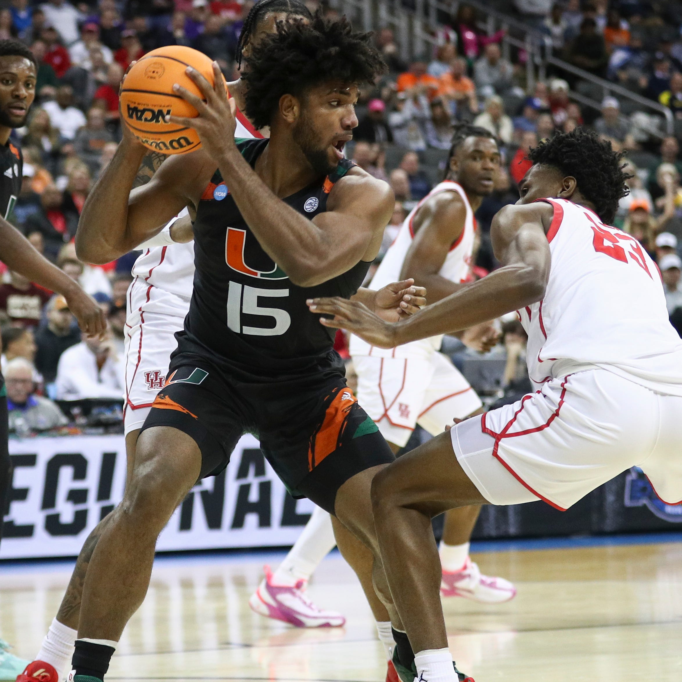 Miami (Fla.) forward Norchad Omier (15) is defended by Houston guard Terrance Arceneaux (23) defends during  their NCAA tournament game at T-Mobile Center.