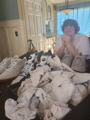 Eric Kilburn of Goodrich with a selection of Reebok size 22 shoes that were originally created for Shaquille O'Neal. The 14-year-old will wear these while awaiting larger shoes that are being custom made for him.