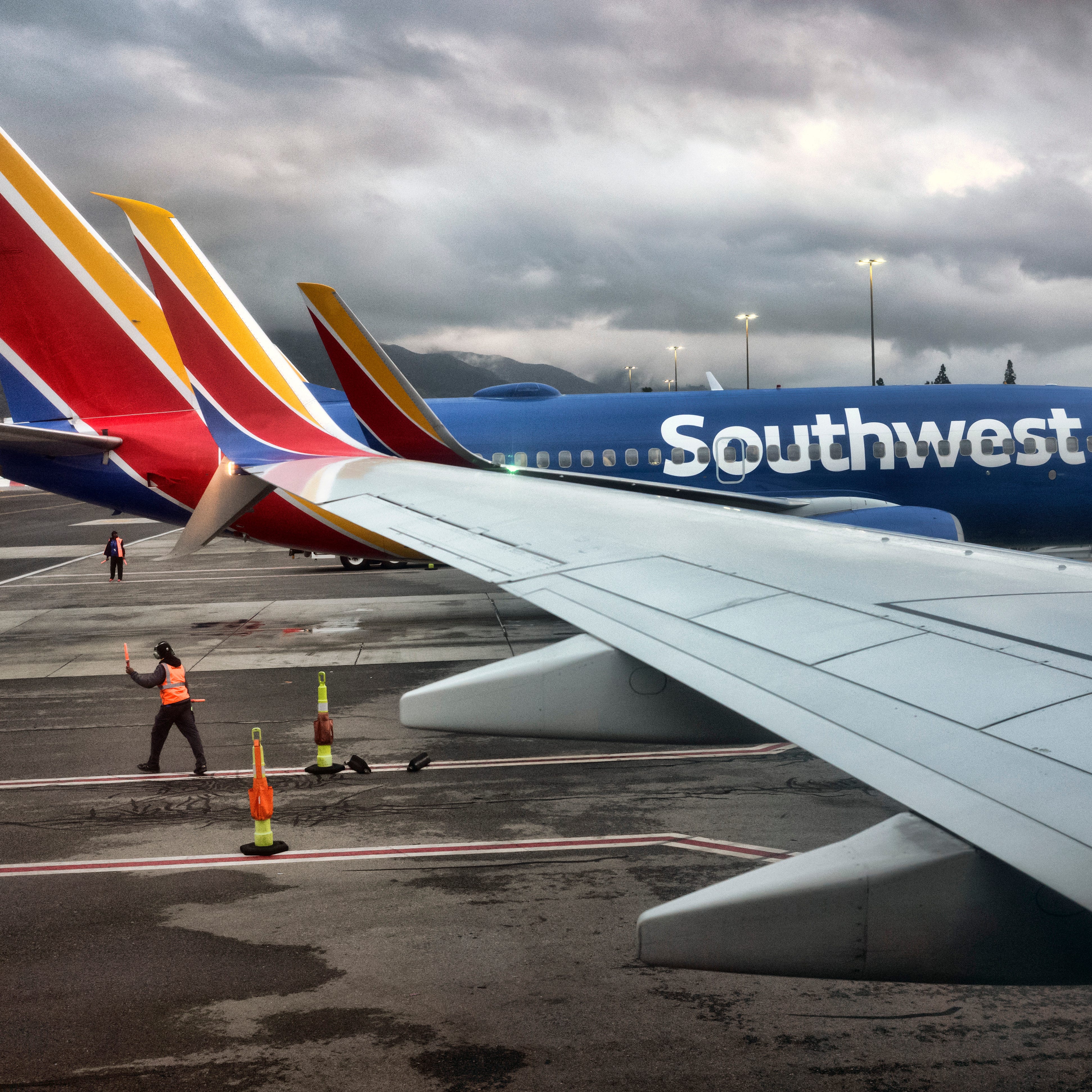 A Southwest Airlines ground crew directs a plane out of the terminal at Hollywood Burbank Airport in Burbank, Calif. on Tuesday, Feb. 14, 2023.