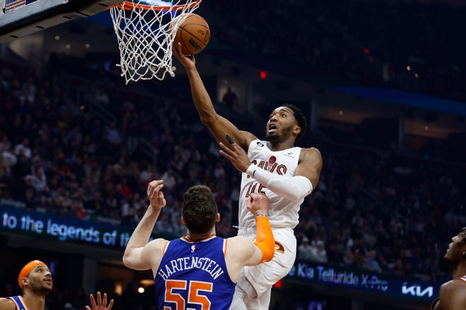 Cleveland Cavaliers guard Donovan Mitchell (45) shoots against New York Knicks center Isaiah Hartenstein (55) during the first half of an NBA basketball game Friday, March 31, 2023, in Cleveland. (AP Photo/Ron Schwane)