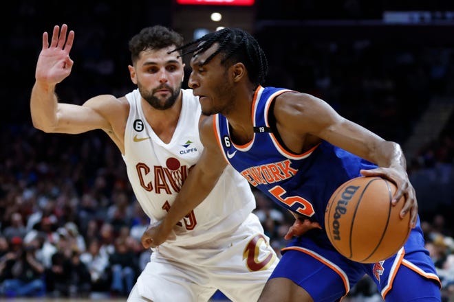 Knicks guard Immanuel Quickley drives against Cavaliers guard Raul Neto, left, during the second half, Friday, March 31, 2023, in Cleveland.
