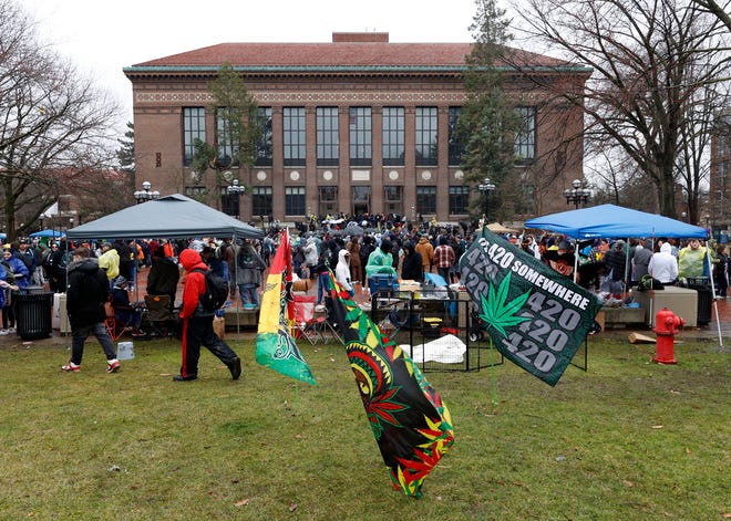People stand at the Diag listening to various speakers during Hash Bash 2023 on the campus of the University of Michigan in Ann Arbor on Saturday, April 1, 2023.