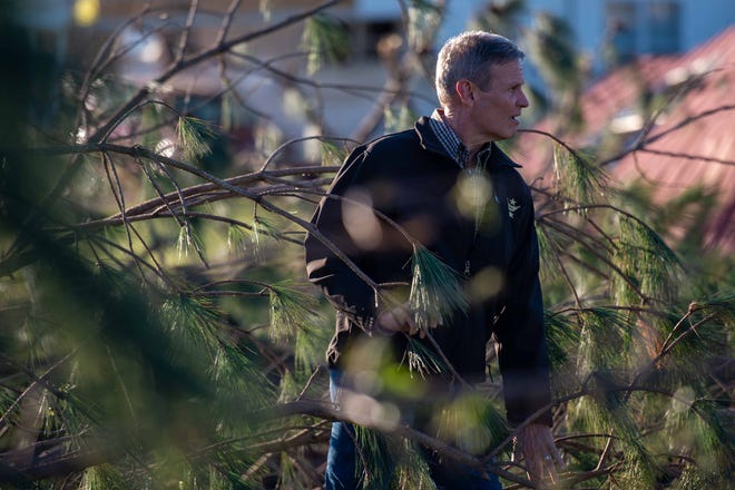 Gov. Bill Lee walks through fallen trees as he makes his way to a tornado damaged home in Adamsville, Tenn. on Saturday, Apr. 1, 2023. A series of storms went through McNairy County throughout the night, resulting in 9 casualties. 