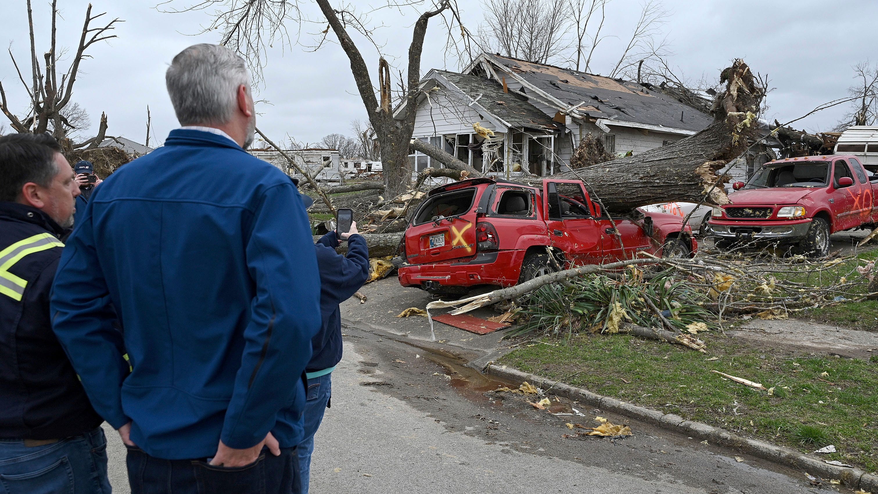 Sullivan Mayor Clint Lamb and Indiana Governor Eric Holcomb survey the damage caused by a tornado on Saturday, April 1, 2023 in Sullivan, Indiana.