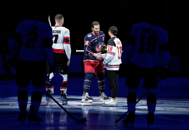 Apr 2, 2023; Columbus, Ohio, USA; Columbus Blue Jackets center Boone Jenner (38) shakes the hand of Ohio State women's hockey defenseman Sophie Jaques after she dropped the ceremonial puck before the game against Ottawa Senators at Nationwide Arena. 