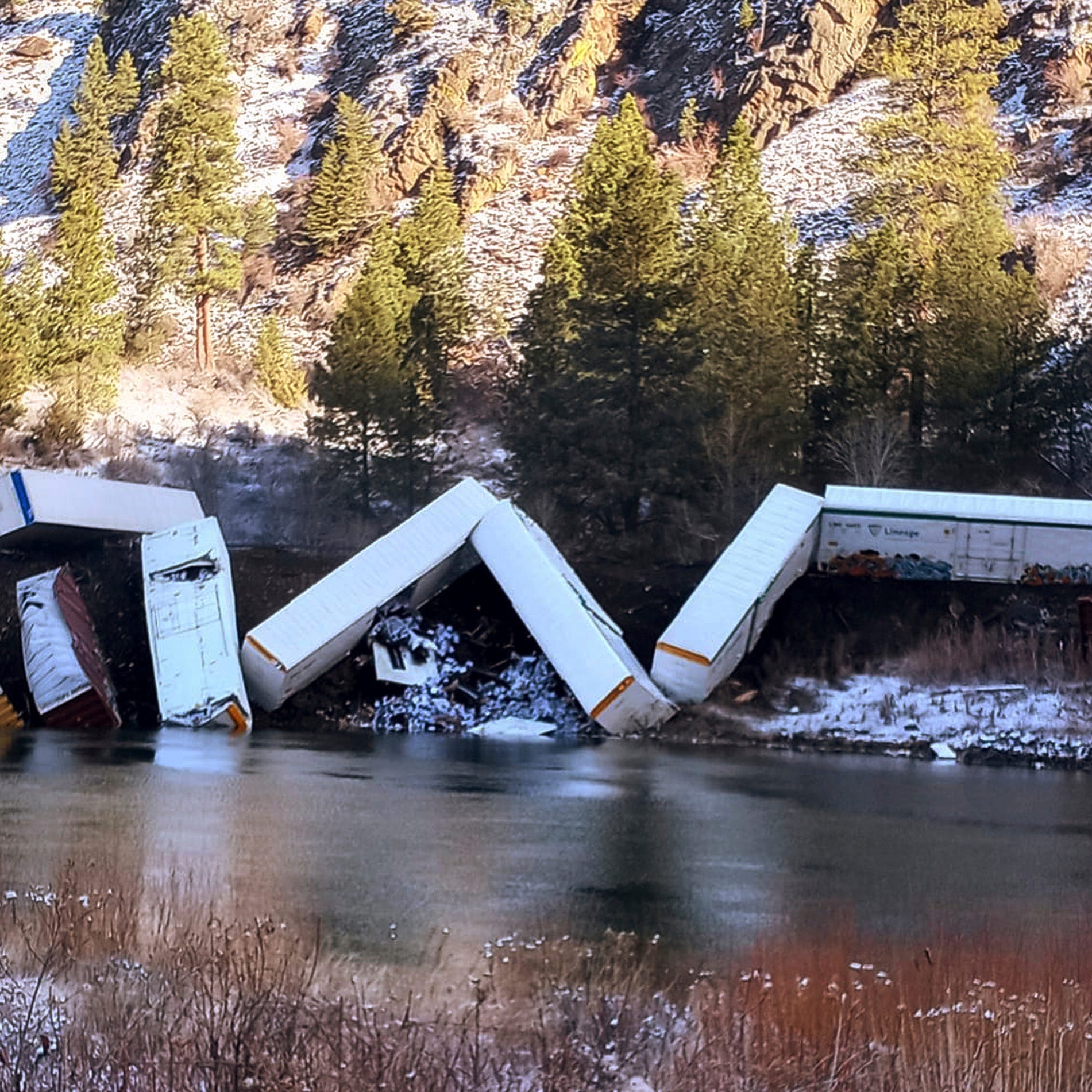 This image provided by Daffney Clairmont shows a train derailed along the Clark Fork River near Paradise, Mont., Sunday, April 2, 2023. Authorities say about 25 train cars derailed.