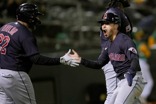 Cleveland Guardians' Steven Kwan, right, is congratulated by Josh Naylor after scoring against the Oakland Athletics during the eighth inning of a baseball game in Oakland, Calif., Monday, April 3, 2023. (AP Photo/Jeff Chiu)