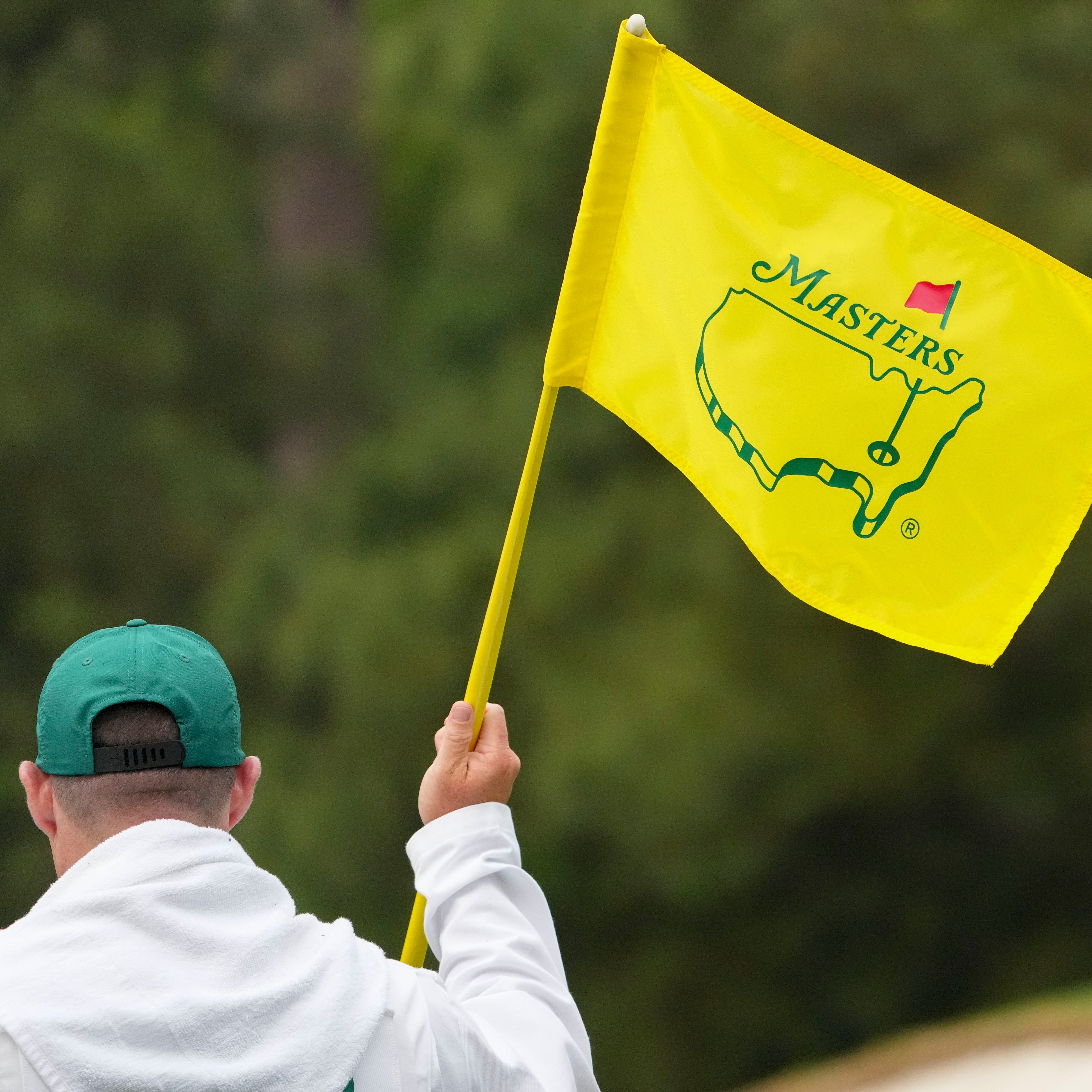 A Masters flag is held on the third green during a practice round for the Masters golf tournament at Augusta National Golf Club.