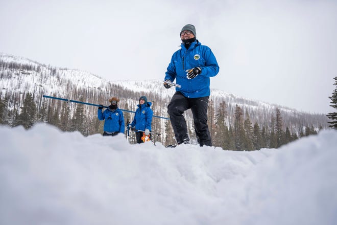 Sean de Guzman, snow survey manager for the Department of Water Resources, right, walks on the snow after he and his team conducted the final snow survey of the season at Phillips Station on Monday, April 3, 2023. It was the deepest snowpack ever recorded. (Hector Amezcua/The Sacramento Bee via AP) ORG XMIT: CASAB102
