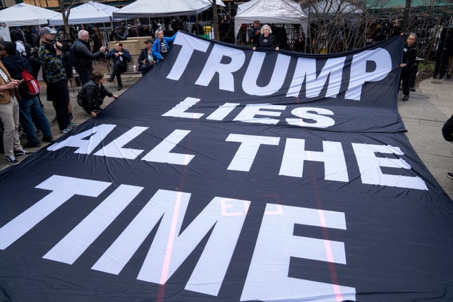 Protesters display a banner criticizing former President Donald Trump outside the Manhattan Criminal Courthouse in New York City on April 4, 2023.