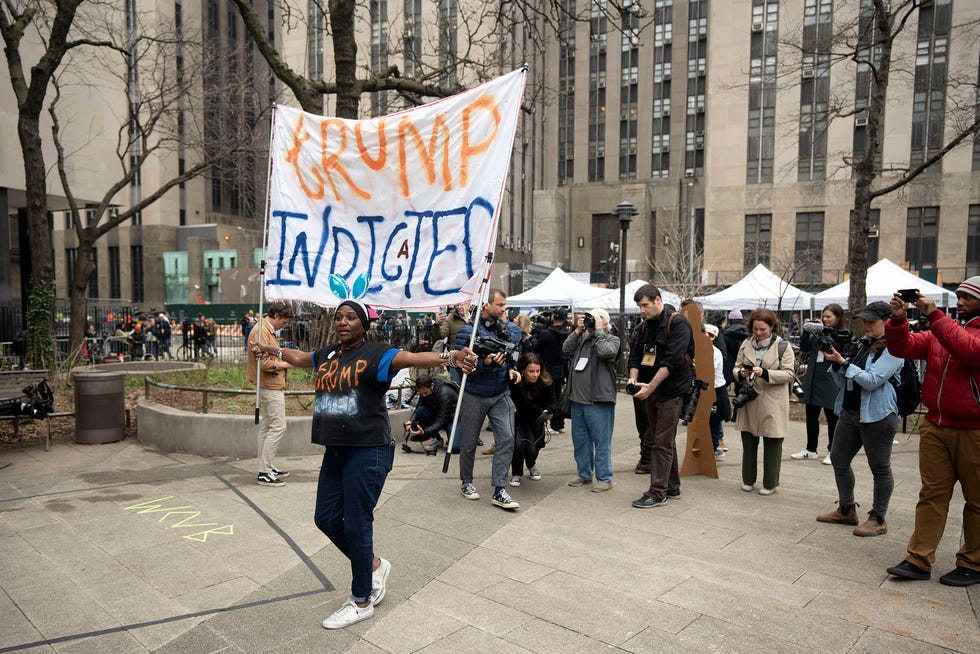 Nadine Seiler holds a banner outside of the Manhattan Criminal Courthouse on Tuesday, April 4, 2023.