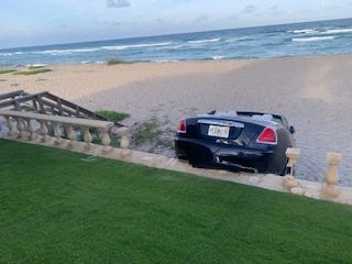 A woman drove her Rolls-Royce sedan through a backyard on Canterbury Lane in Palm Beach, then through a seawall, before coming to rest on the beach, Palm Beach Police say. (Palm Beach Police)