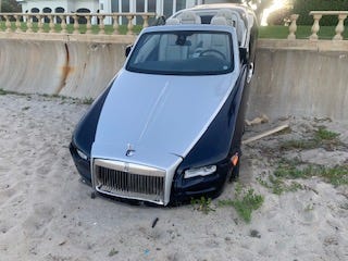 A woman drove her Rolls-Royce sedan through a backyard on Canterbury Lane in Palm Beach, then through a seawall, before coming to rest on the beach, Palm Beach Police say. (Palm Beach Police)
