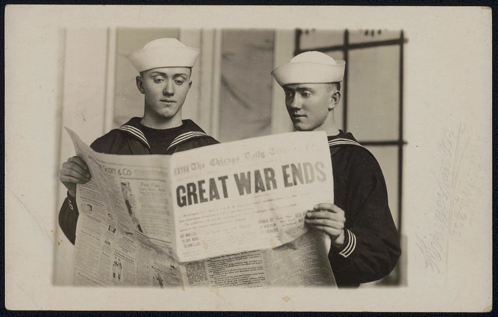 Two unidentified sailors holding copy of the Chicago Daily Tribune with the headline "Great War Ends."