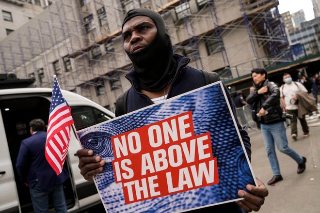 A demonstrator marches near the New York City courthouse where former President Donald Trump was arraigned on April 4, 2023.