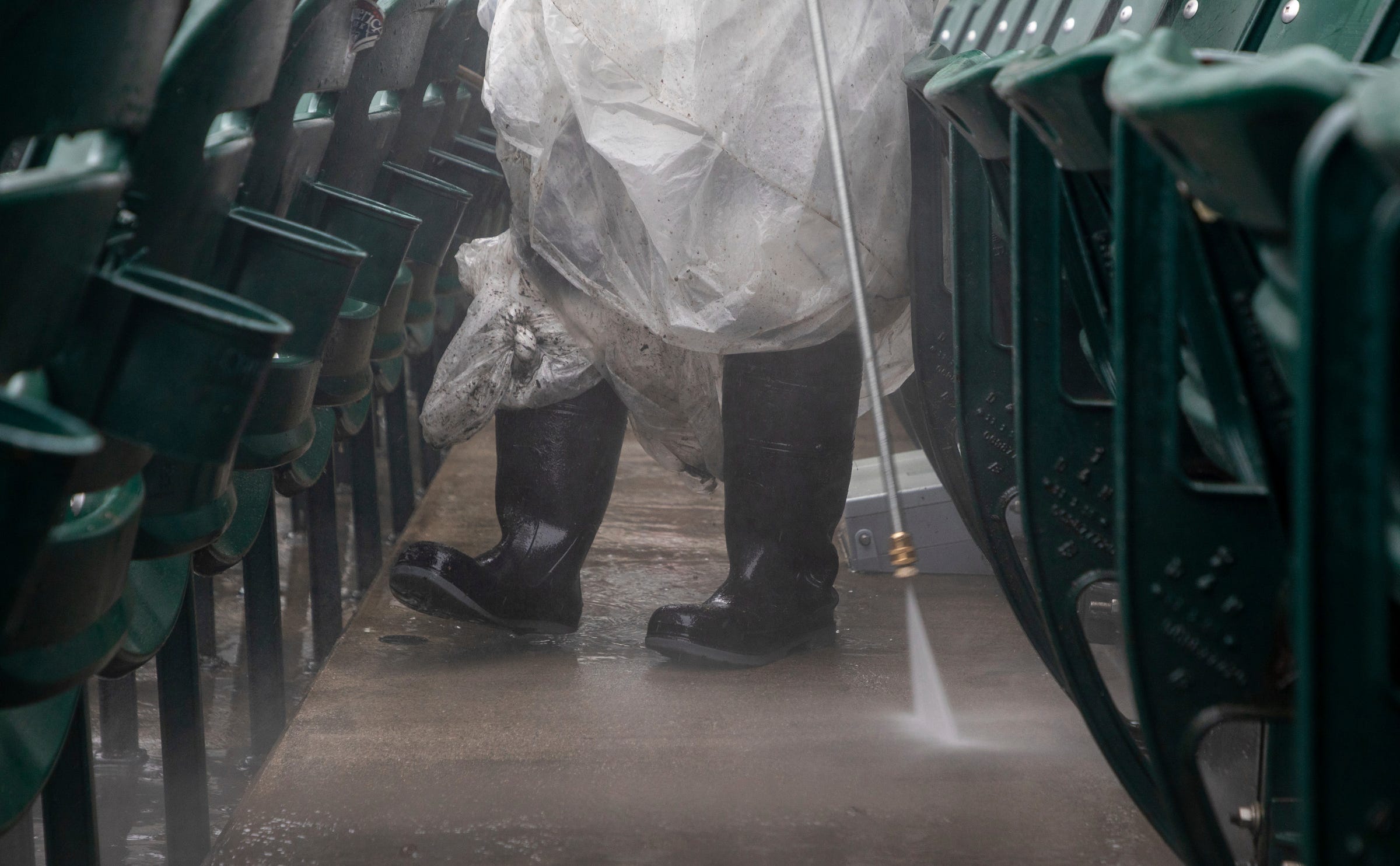 Marquise Pope, of Detroit, uses a pressure washer to clean the seat isles inside Comerica Park on Tuesday, April 4, 2023.