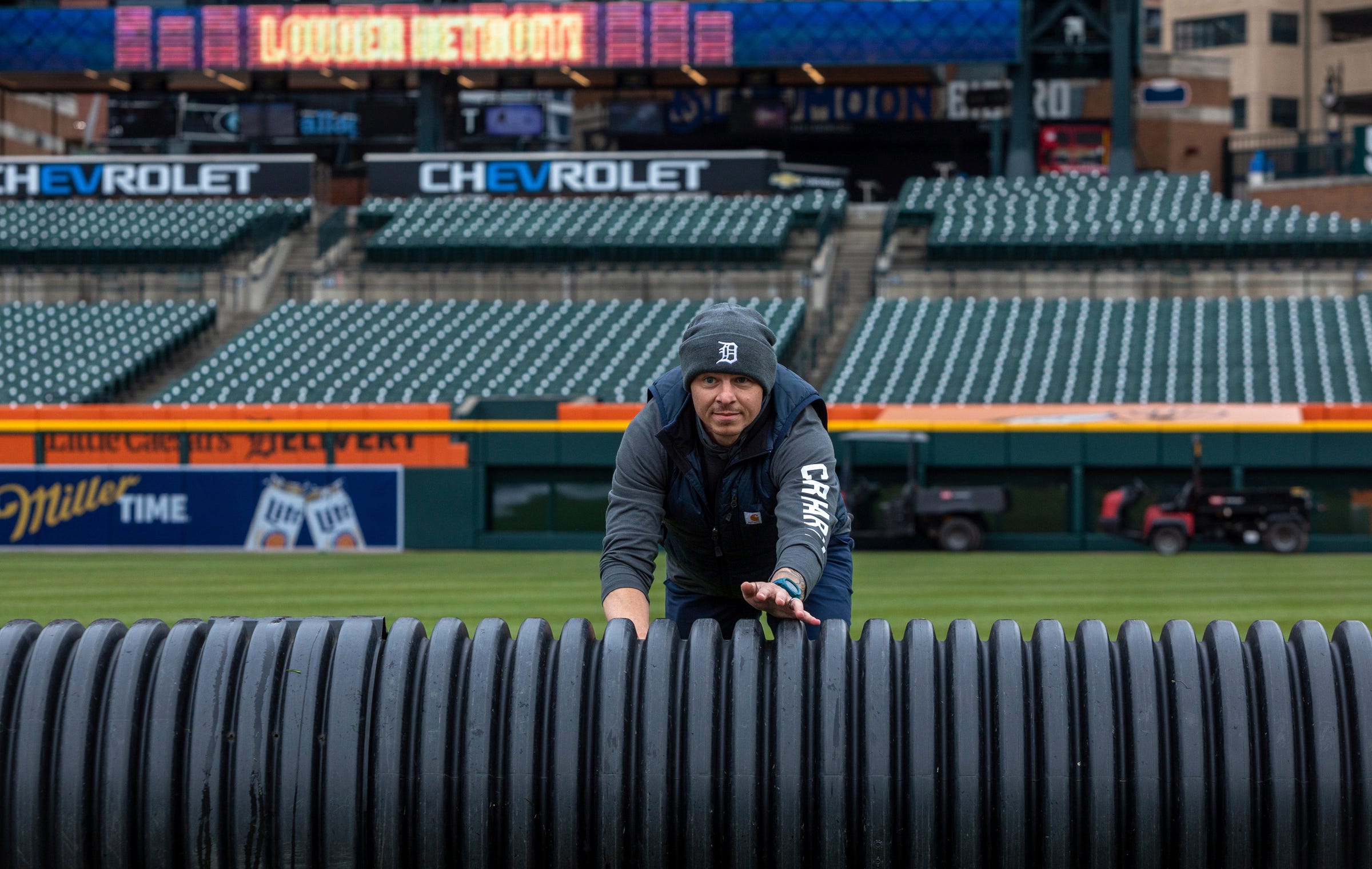 Kyle Pickens, assistant groundskeeper, helps push a giant tube inside Comerica Park on Tuesday, April 4, 2023.