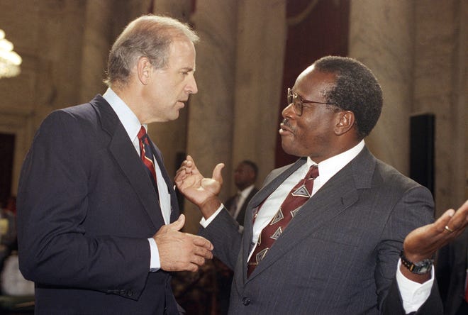 Then-Supreme Court Justice Clarence Thomas gestures while talking with Joe Biden, chairman of the Senate Judiciary Committee, during a break in Thomas confirmation hearing in 1991.