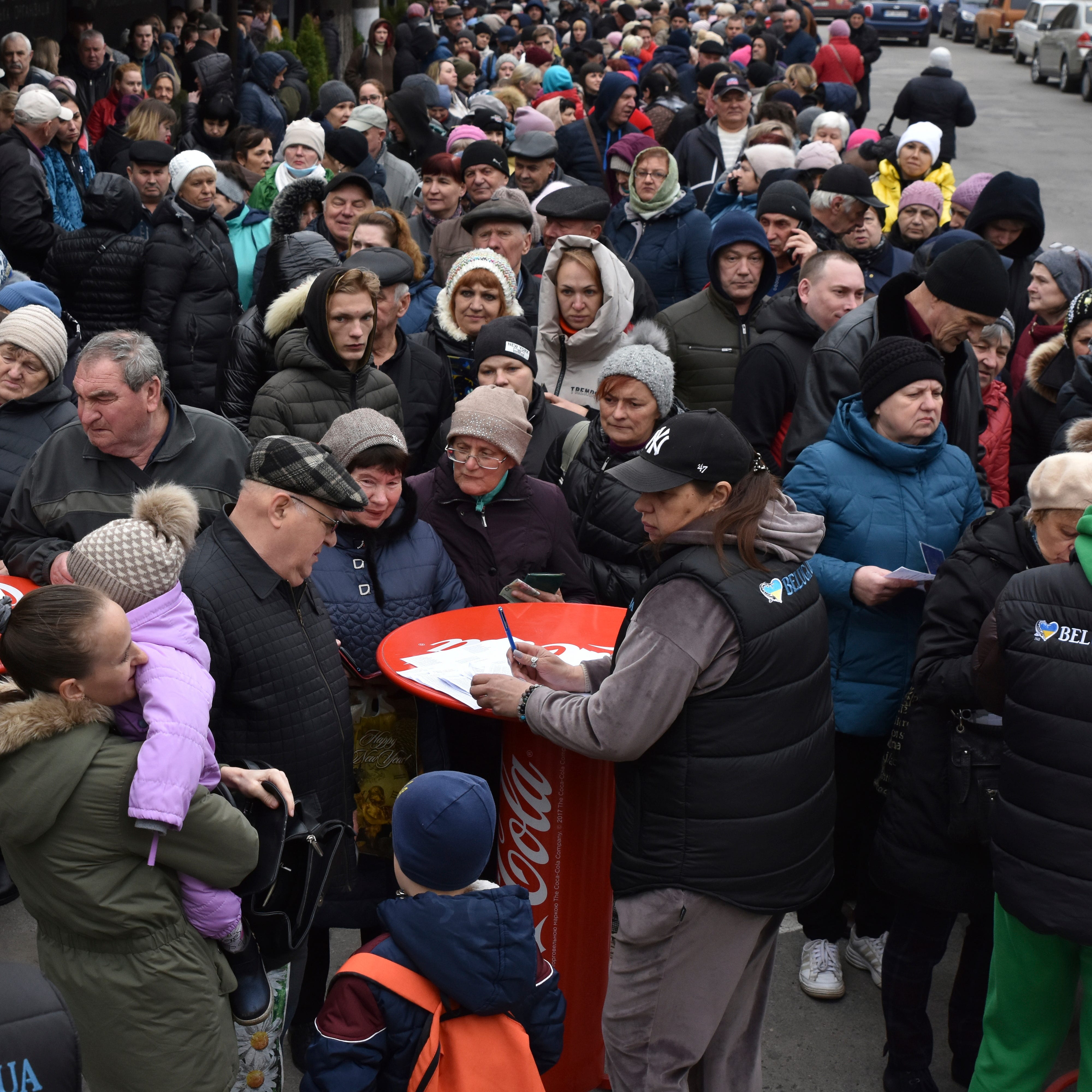 People receive humanitarian aid at a distribution spot in Zaporizhzhya, Ukraine, on April 7, 2023.