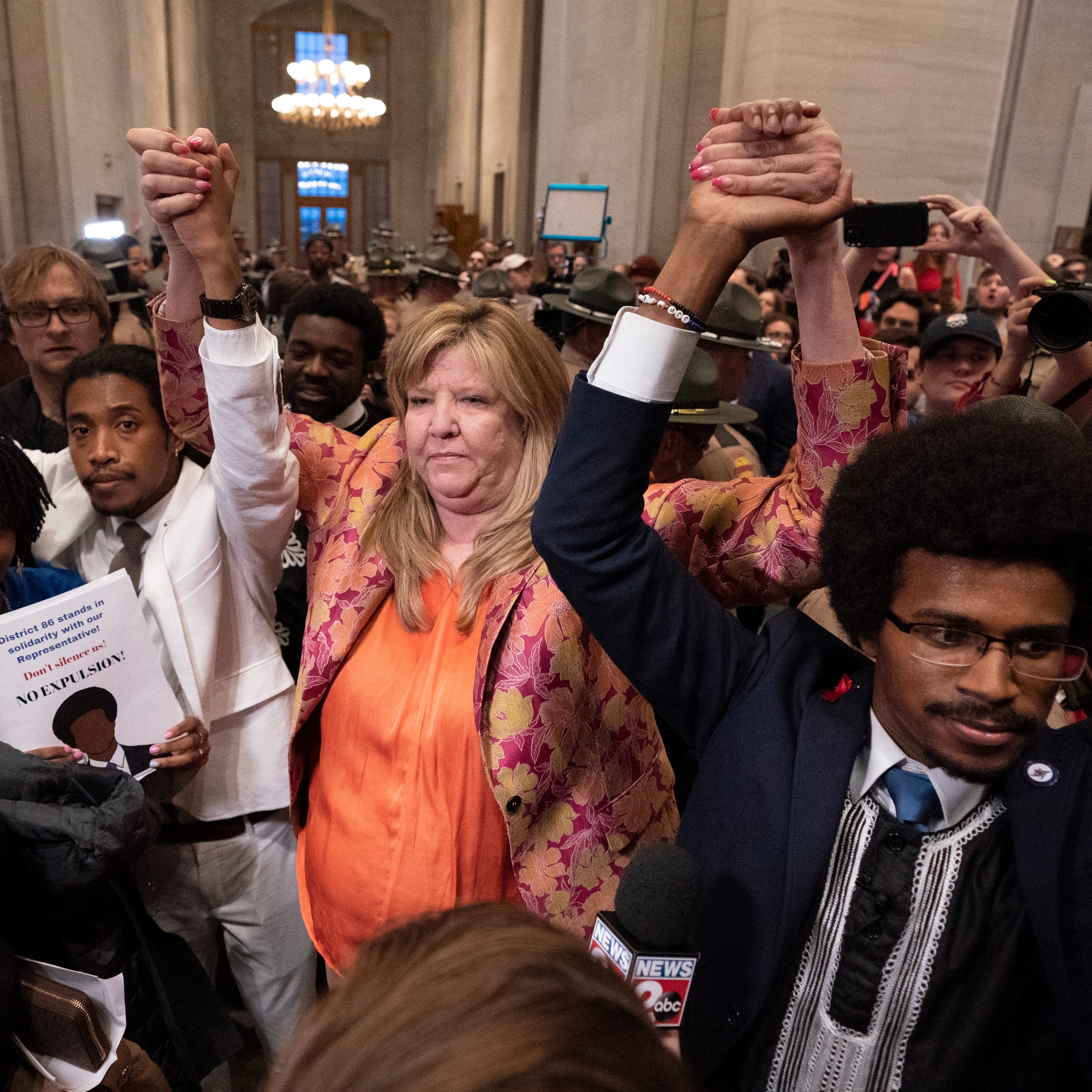 Rep. Justin Jones, in white, Rep. Gloria Johnson and Rep. Justin Pearson raise their hands outside the House chamber after Jones and Pearson were expelled from the legislature on April 6, 2023, in Nashville, Tenn.