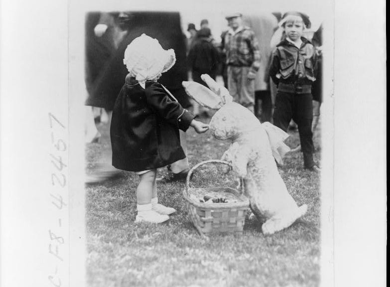 Little girl pretending to feed toy rabbit on April 1, 1929.