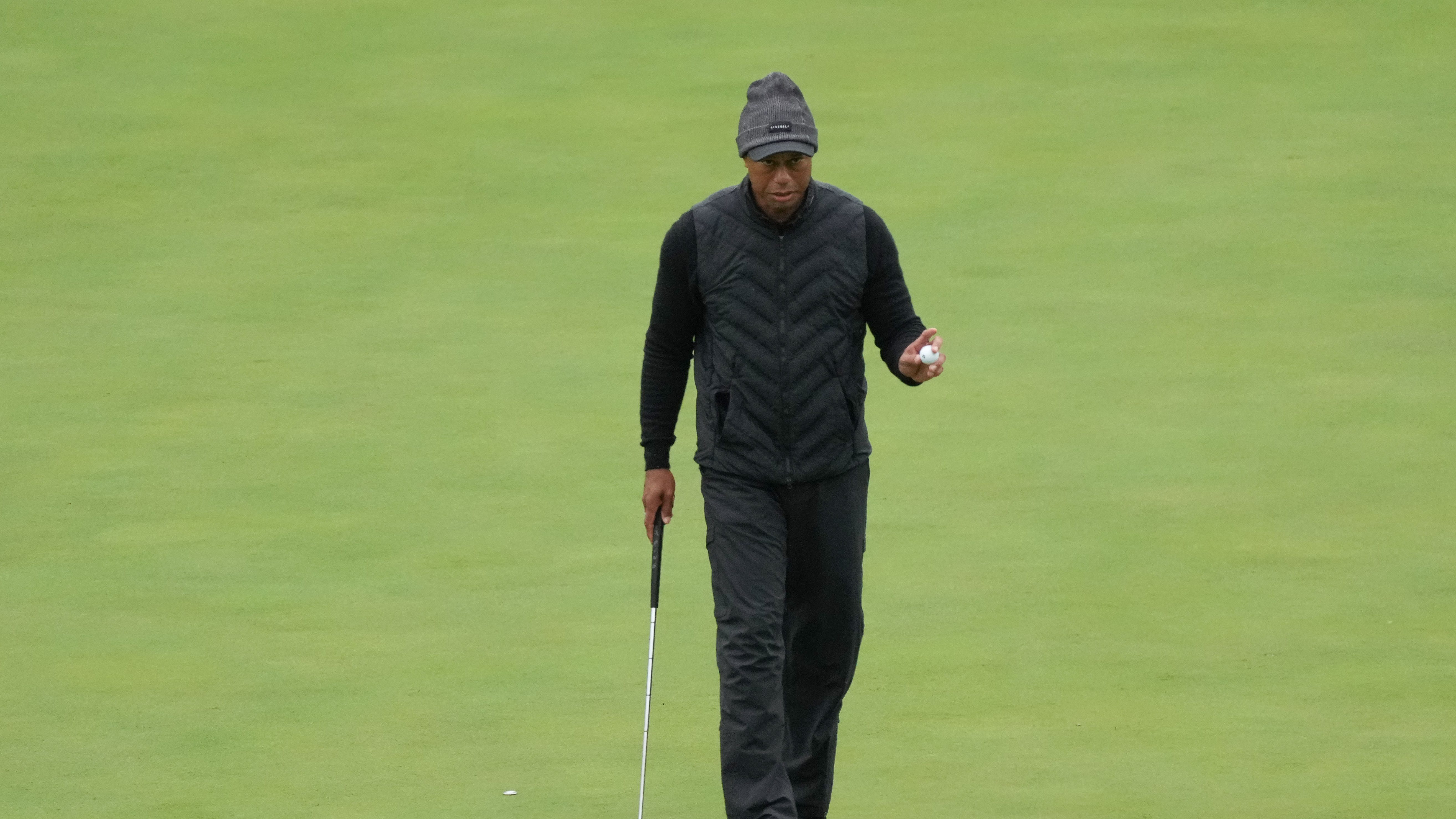 Tiger Woods acknowledges patrons after a putt on the eleventh green during the third round.