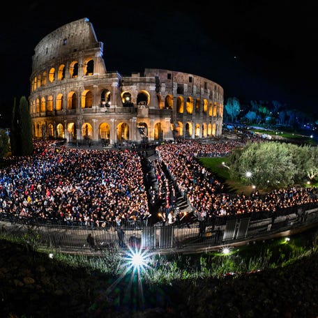 A general view shows people gather by the Colosseum monument in Rome during the Way of the Cross (Via Crucis) prayer service in Rome on April 7, 2023 as part of celebrations of the Holy Week.