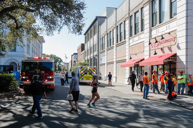 Pedestrians cross State Street as emergency crews begin to leave the area following the partial collapse of the third floor inside the Tomochichi Federal Building on Wright Square on Tuesday afternoon.