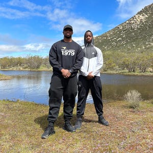 Faheem Ra'id Muhammad, 13, stands with his father, Faheem Muhammad, on part of the 40 acres of land he received for his birthday on March 16, 2023.
