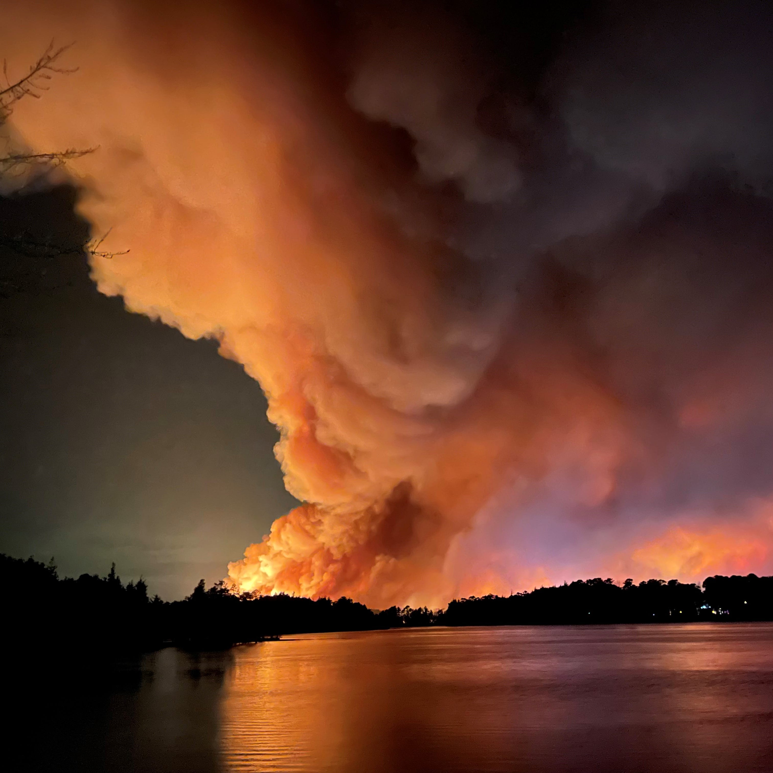 Smoke billows from across Lake Horicon in Lakehurst where a major wildfire threatened the town early Wednesday, April 12, 2023.