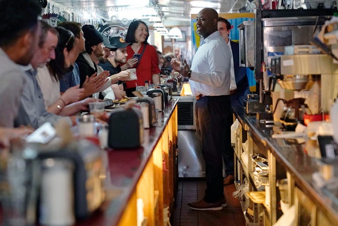 Sen. Tim Scott, R-S.C., talks with diners and reporters during a visit to the Red Arrow Diner, Thursday, April 13, 2023, in Manchester, N.H. Scott on Wednesday launched an exploratory committee for a 2024 GOP presidential bid, a step that comes just shy of making his campaign official.