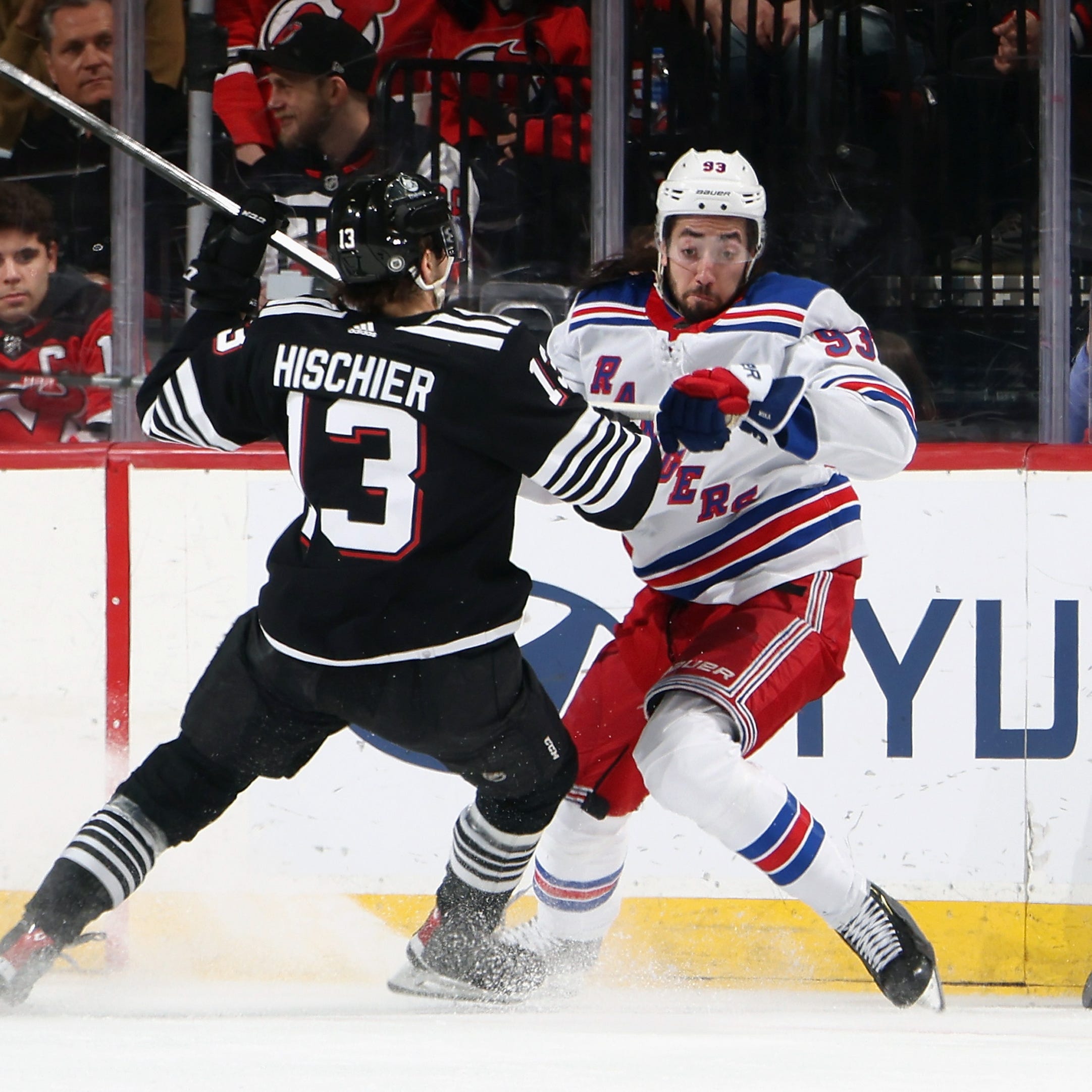 NEWARK, NEW JERSEY - MARCH 30: Nico Hischier #13 of the New Jersey Devils checks Mika Zibanejad #93 of the New York Rangers during the second period at the Prudential Center on March 30, 2023 in Newark, New Jersey.