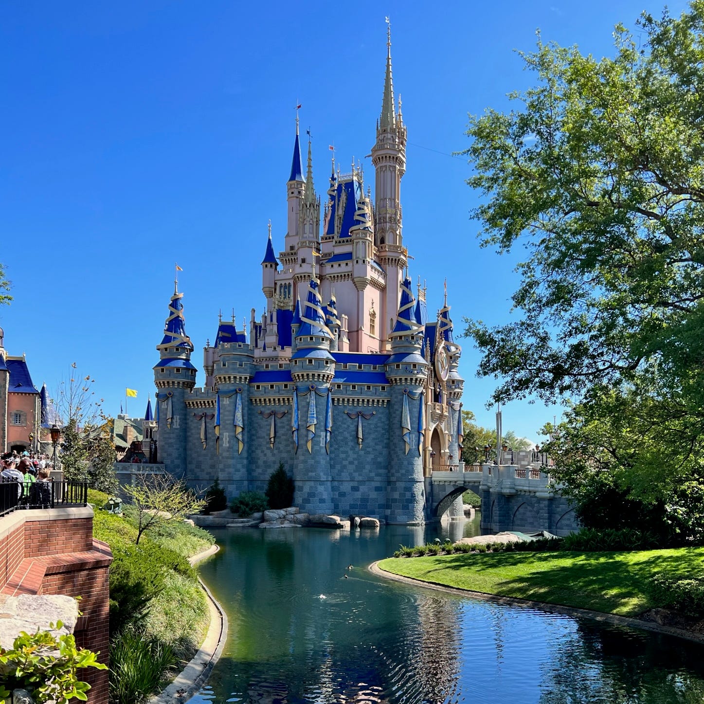 Cinderella Castle is reflected on the water near Liberty Square in Magic Kingdom.