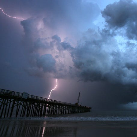 A vein of lightning strikes beyond the Flagler Pier, in Flagler Beach, Fla., as a summer storm rolls south, Saturday, July 18, 2009.