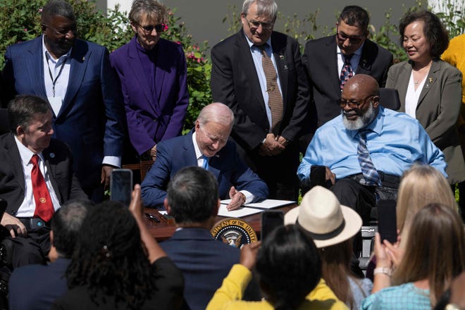 President Joe Biden signs an executive order Tuesday to increase access to high-quality care and support for caregivers during a ceremony in the White House Rose Garden.