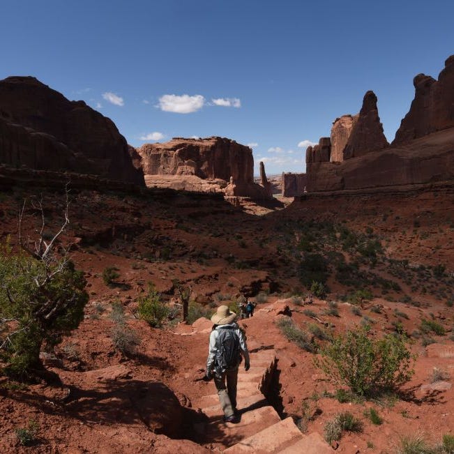 Hikers make their way along Park Avenue trail in Arches National Park near Moab, Utah on April 21, 2018.