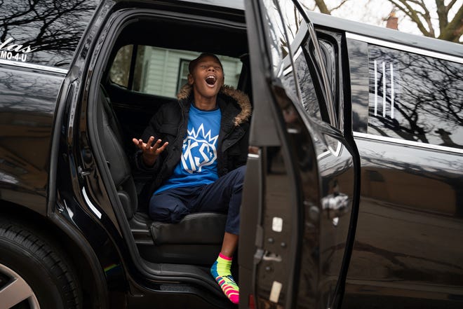 Fifth grader Kenyon Sims, 11, who was diagnosed with osteosarcoma bone cancer in 2020, sings a high note with excitement while sitting in a limousine after attending a school assembly to celebrate his birthday at Detroit Premier Academy in Detroit on Monday, Dec. 5, 2022.