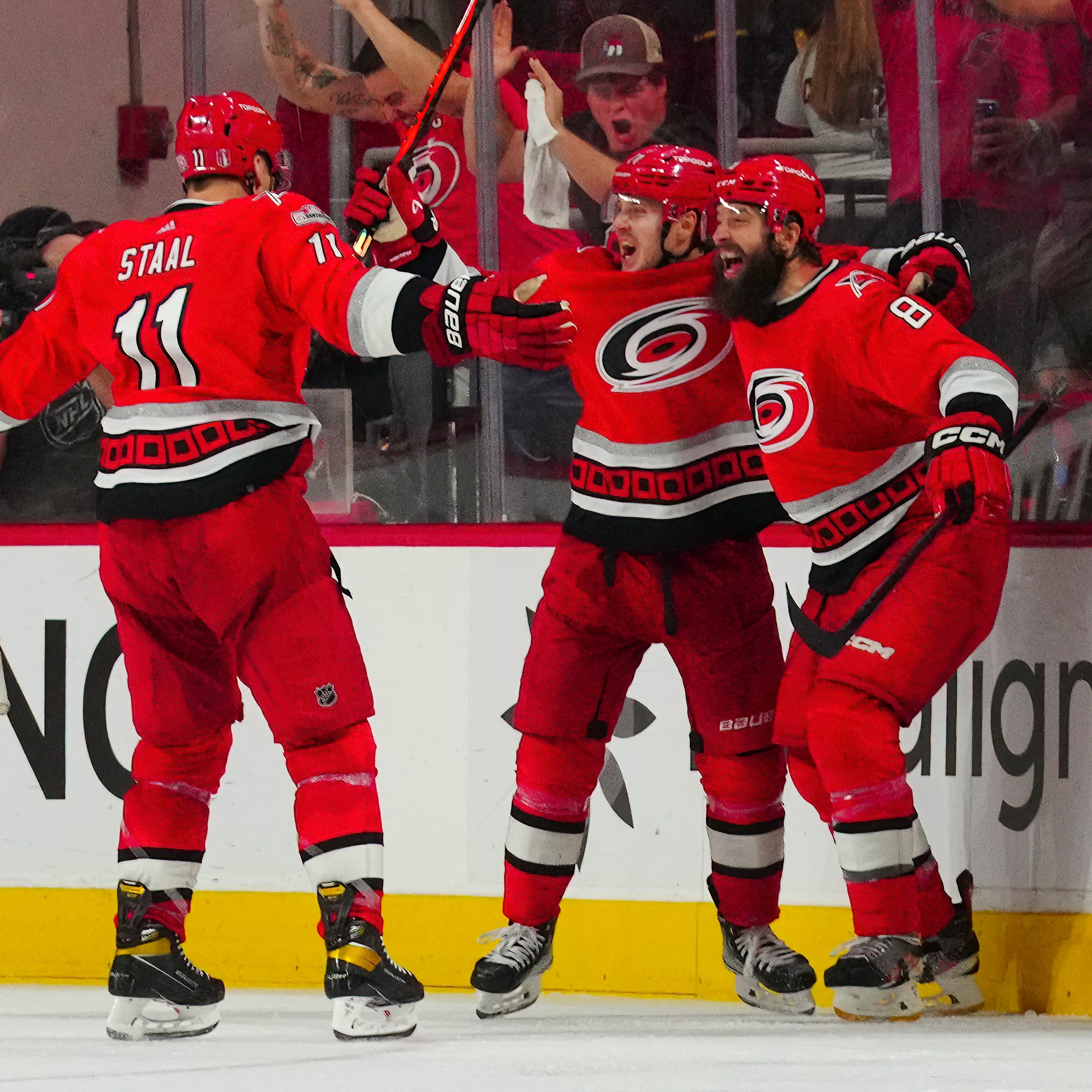Carolina Hurricanes right wing Jesper Fast celebrates his game-winner with Brent Burns and Jordan Staal.