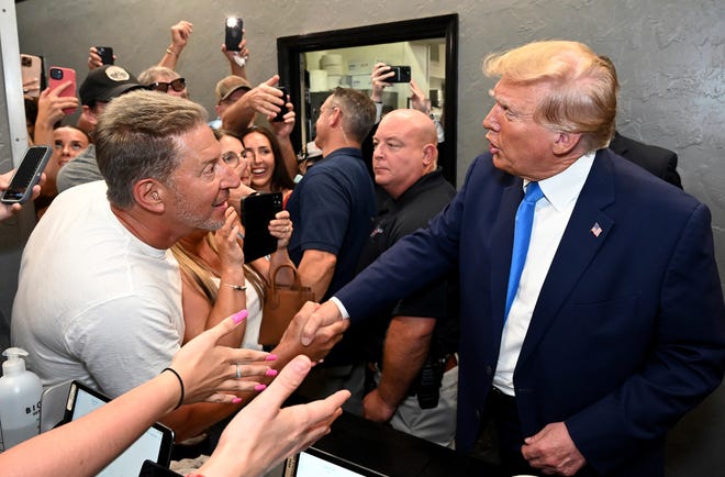 Former President Donald Trump stops by Downtown House of Pizza as he greets his supporters after giving a speech during Lee County Republican dinner in Fort Myers. Trump was critical of Gov. Ron DeSantis in that address as well.