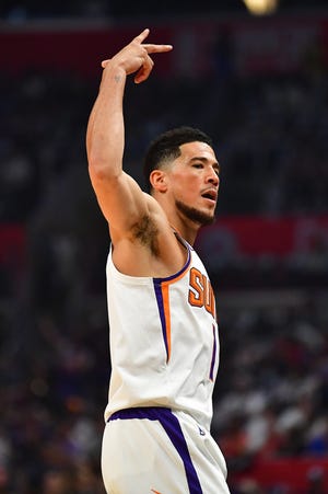 Guard Phoenix Suns Devin Booker (1) bereaksi setelah mencetak tiga angka melawan Los Angeles Clippers pada paruh pertama di game keempat playoff NBA 2023 di Crypto.com Arena pada 22 April 2023.