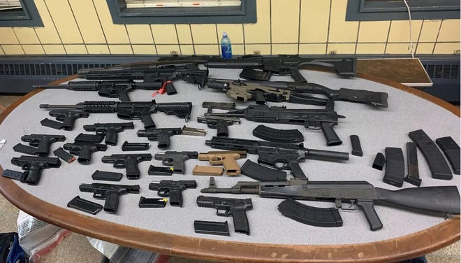 Federal agents seized 23 firearms shown here from two suspects they say were illegally trafficking guns from Ohio to the Bronx in August 2022. The pair are charged with new gun trafficking law signed by President Biden.